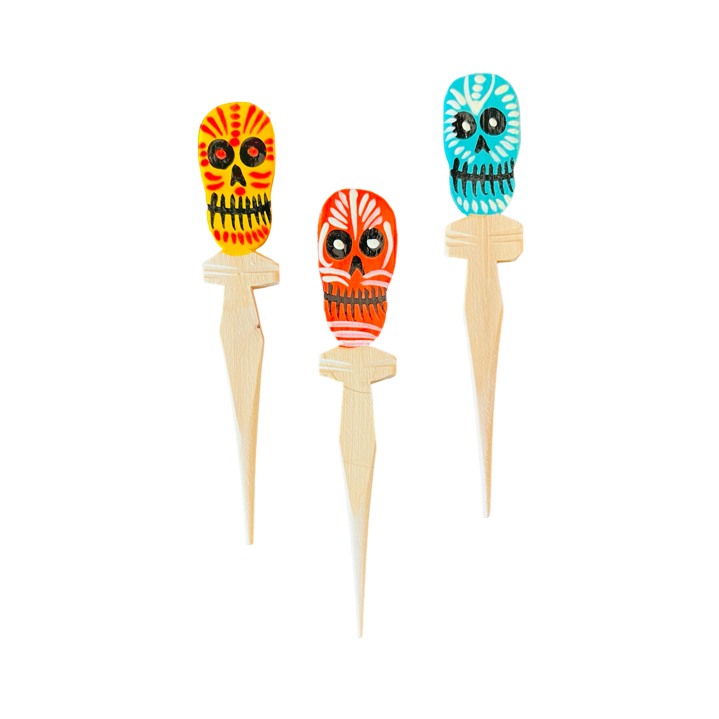 three multi-colored wooden spoons with a sugar skull on top