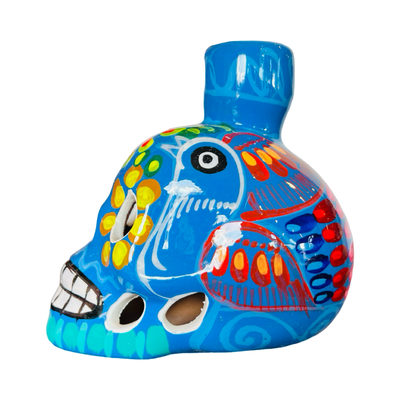 side view of a blue ceramic sugar skull candle holder with a multi-color floral design.