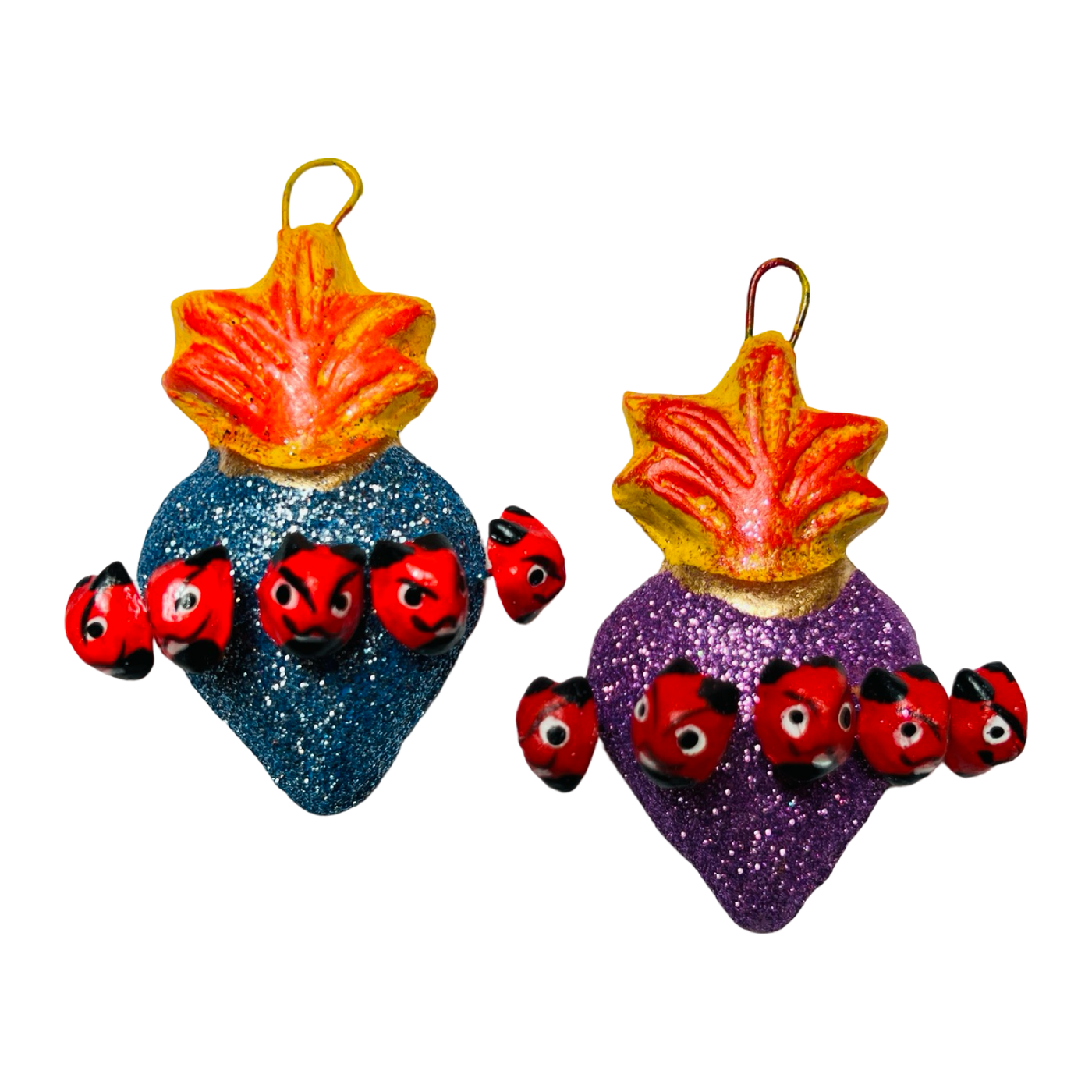 set of multi-colored glitter sacred hearts with devil heads surrounding it.