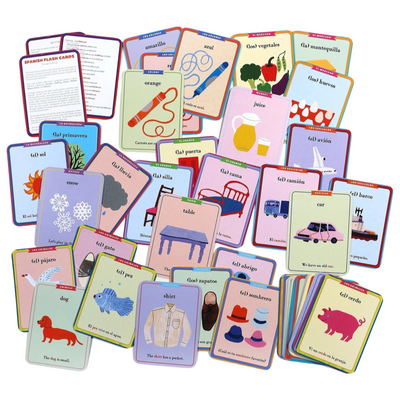 pile of colored flash cards with various images of animals and objects with both English and Spanish words of the images on the cards.