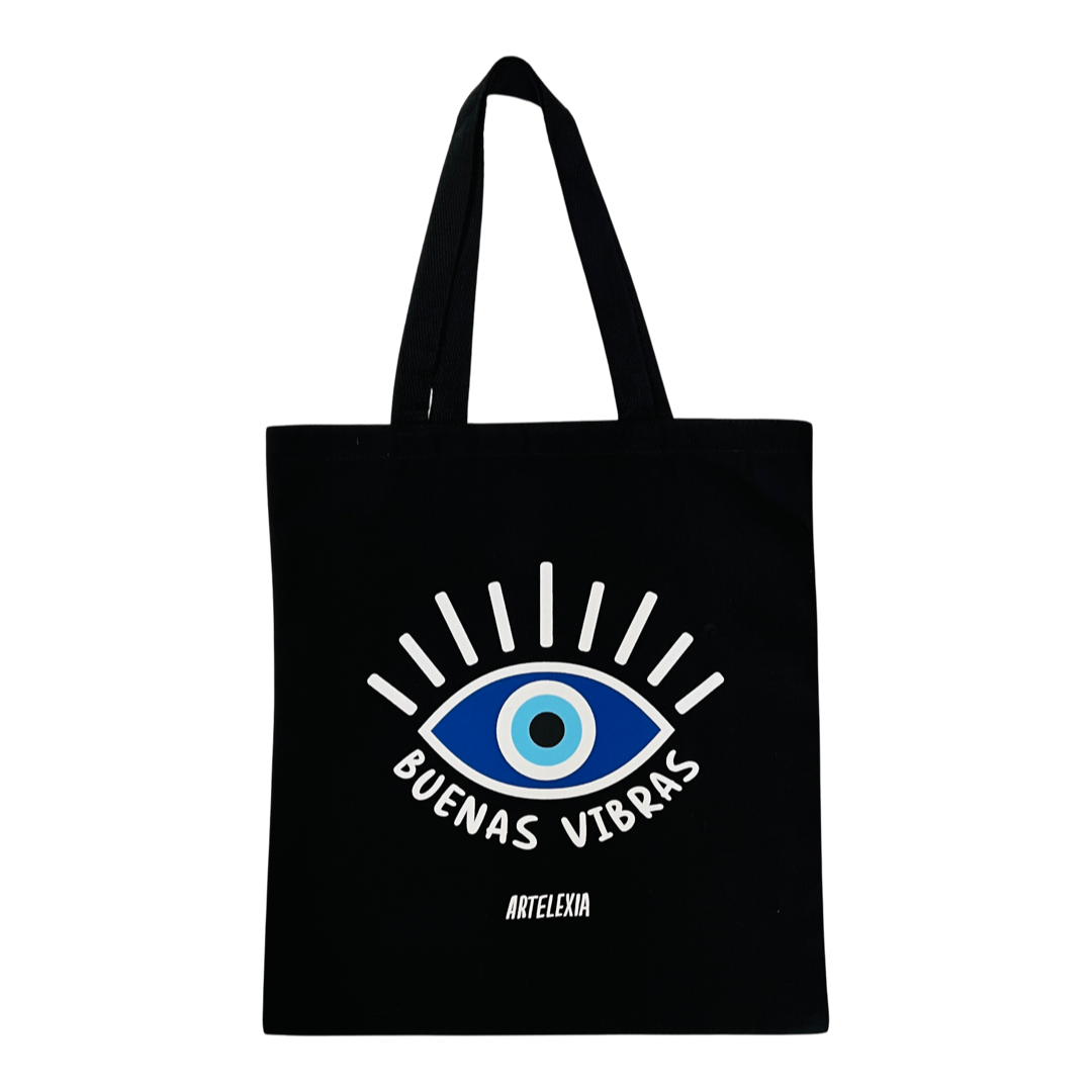 black tote bag with a blue and white eye and the phrase Buenas VIbras in white lettering