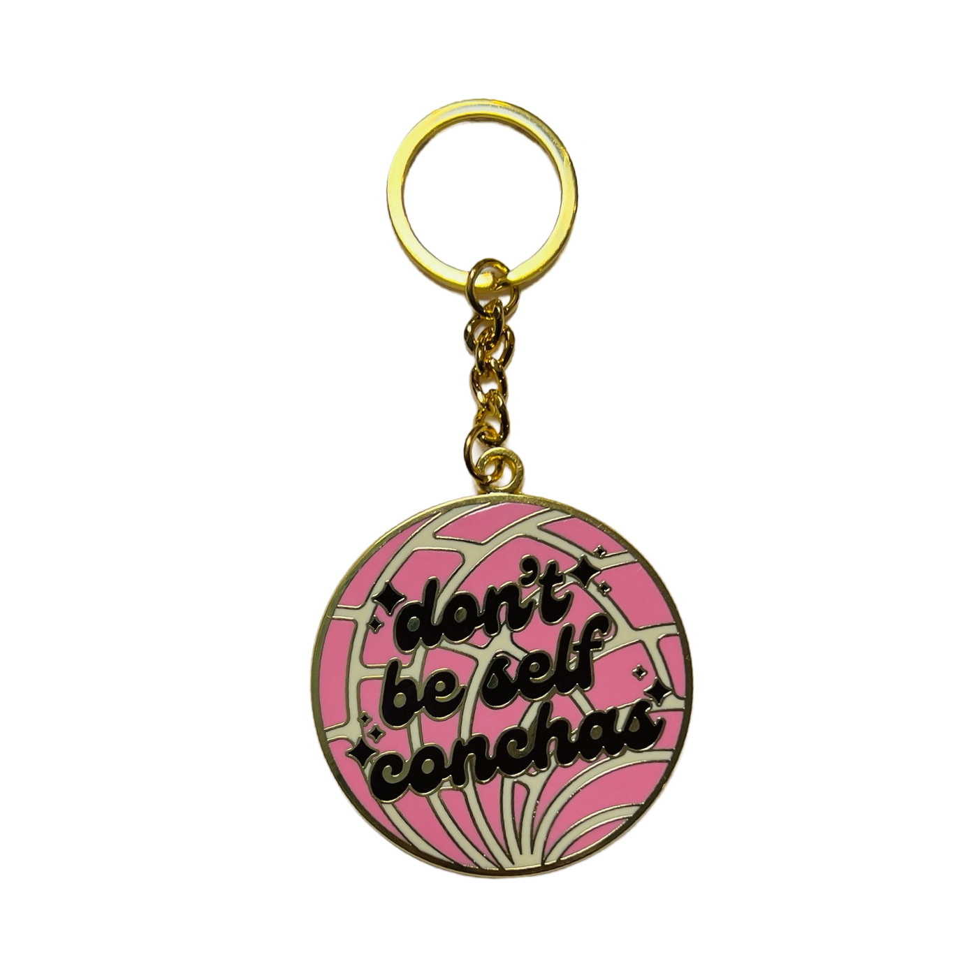 round pink concha enamel keychain with the phrase Don't Be self Conchas in dark brown lettering with gold ring.