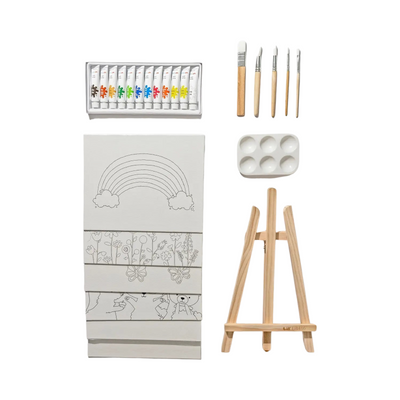 Children's art kit contents laid out, including a set of acrylic paints, five paintbrushes, paint palette, mini wooden easel, and several pre-drawn canvases with designs such as a rainbow, flowers, and animals