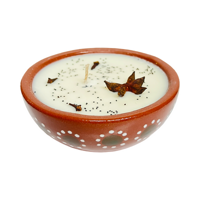 top view of a barro bowl candle that features dried flowers and herbs