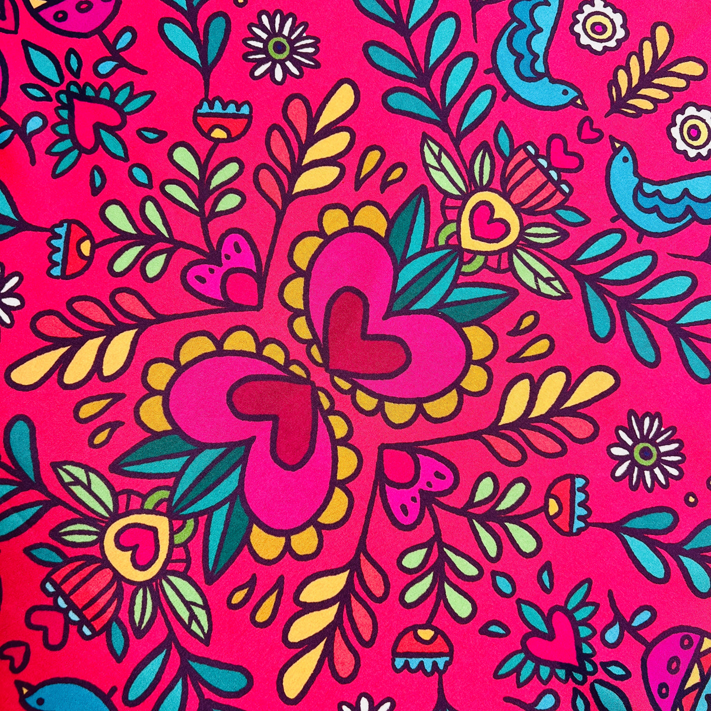 close up of a fuschia scarf with multi-colored floral motifs, butterflies, and birds,