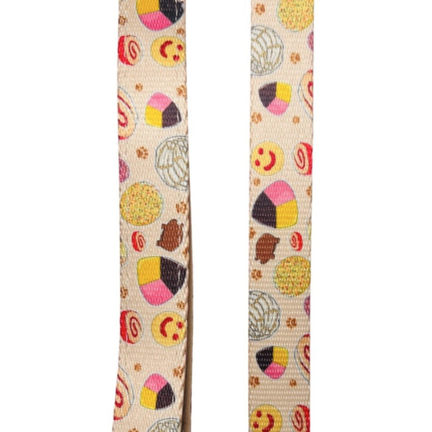 close up of a light yellow dog leash with images of pan dulce.