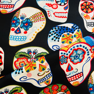 close up of black fabric with images of coloful skulls