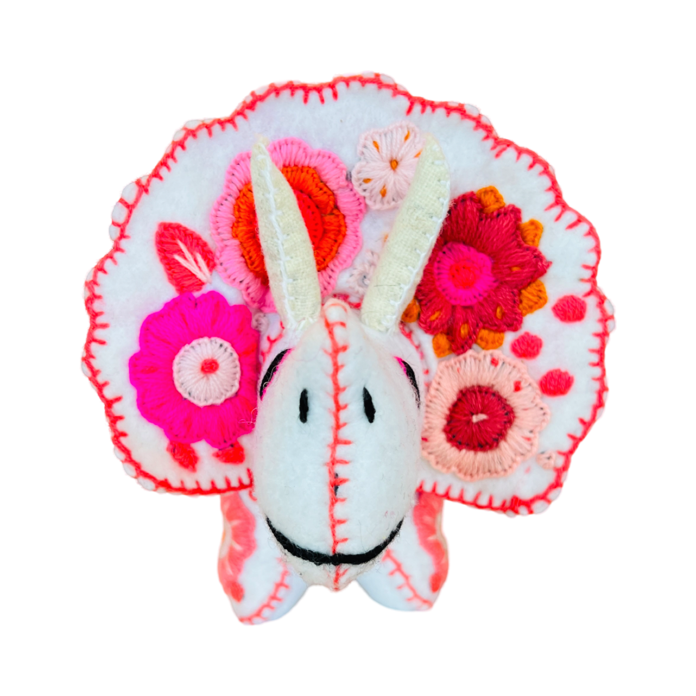 front view of a white felt triceratops with a floral embroidered design