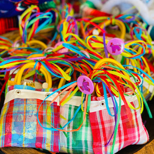 Photo of Artelexia goodie bags. Bags feature varying color combinations and are tied with colorful ribbon
