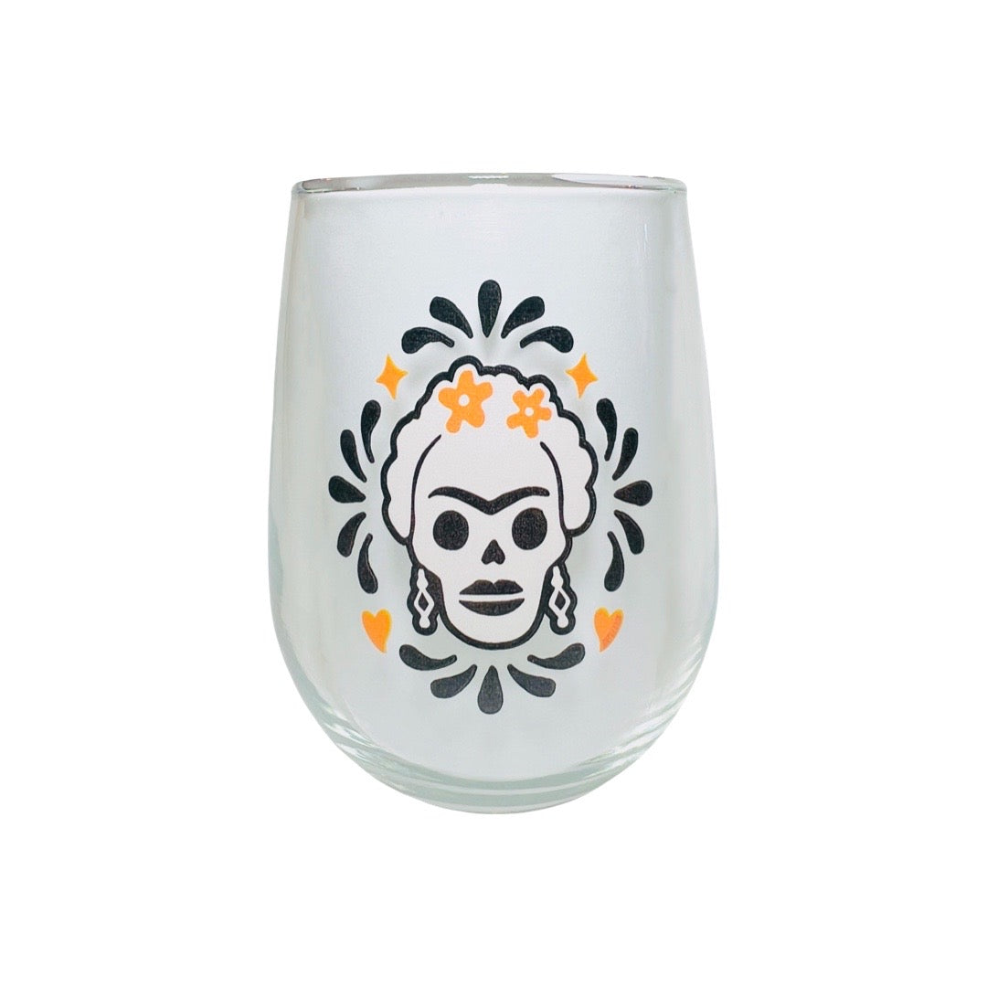 clear stemless glass with an Frida Calavera image featuring black and orange design surrounding the image.