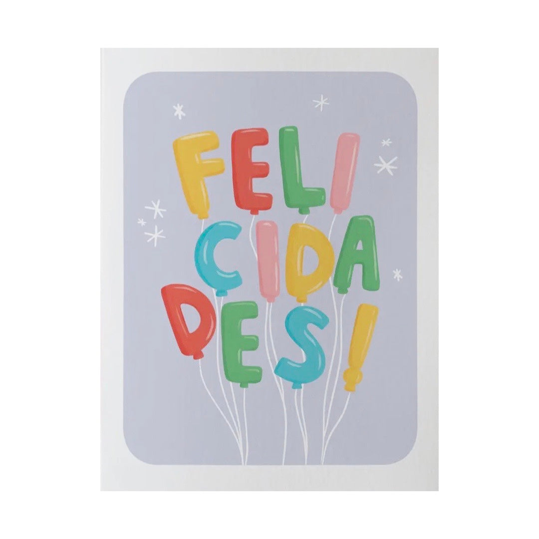 White and lavendar card with the phrase Felicidades in a multi-colored balloon design