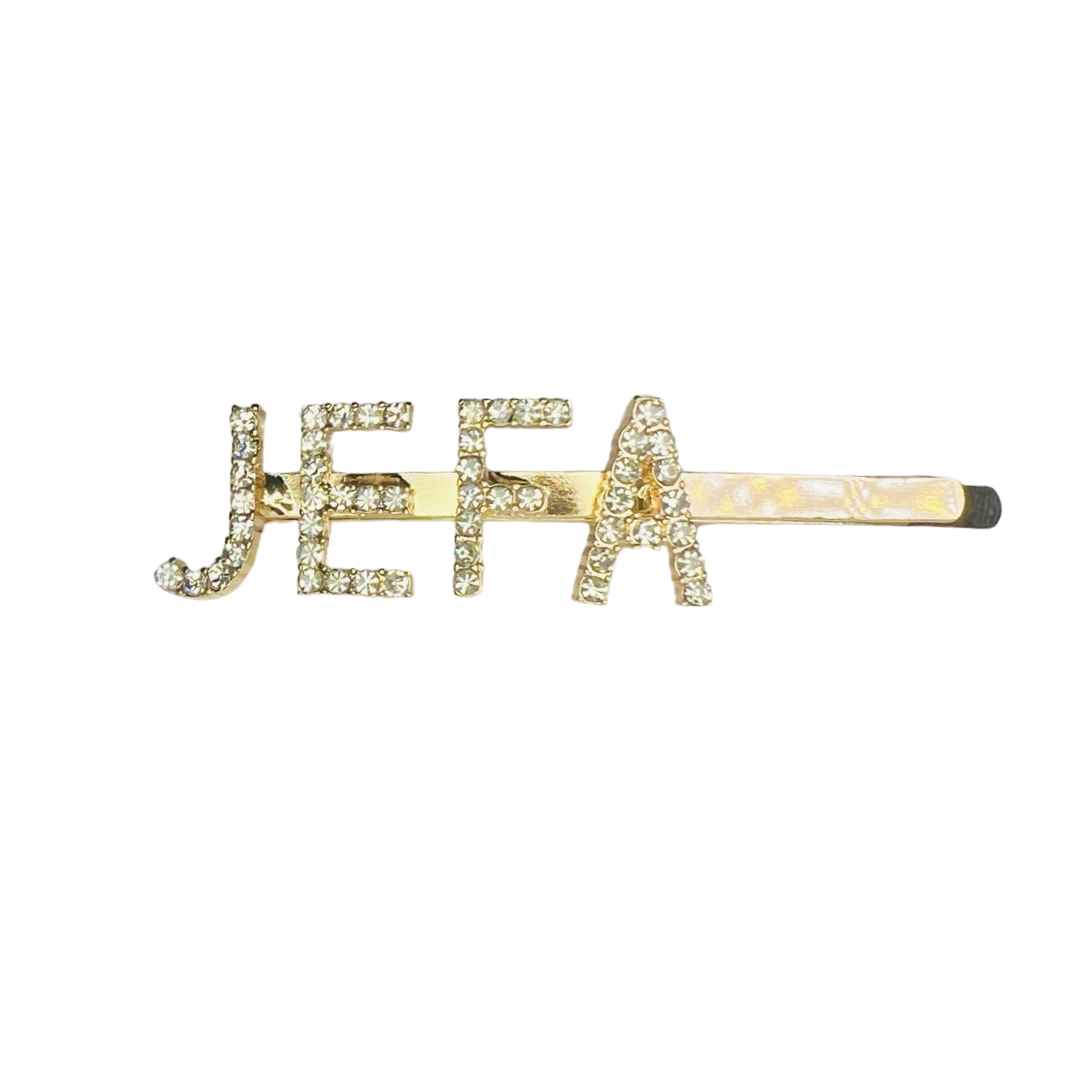 gold hair pin with the word JEFA in gems