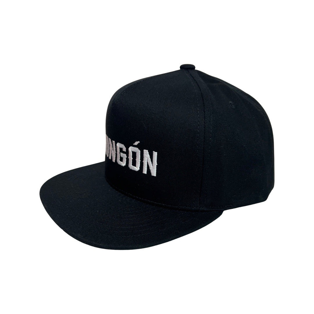side view of a Black snap back hat with the word Chingon in white lettering