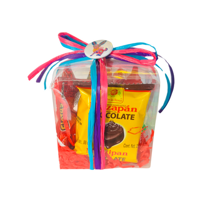 Clear box filled with Mexican candy, red tissue paper and tied with colorful ribbon and a pin-button.