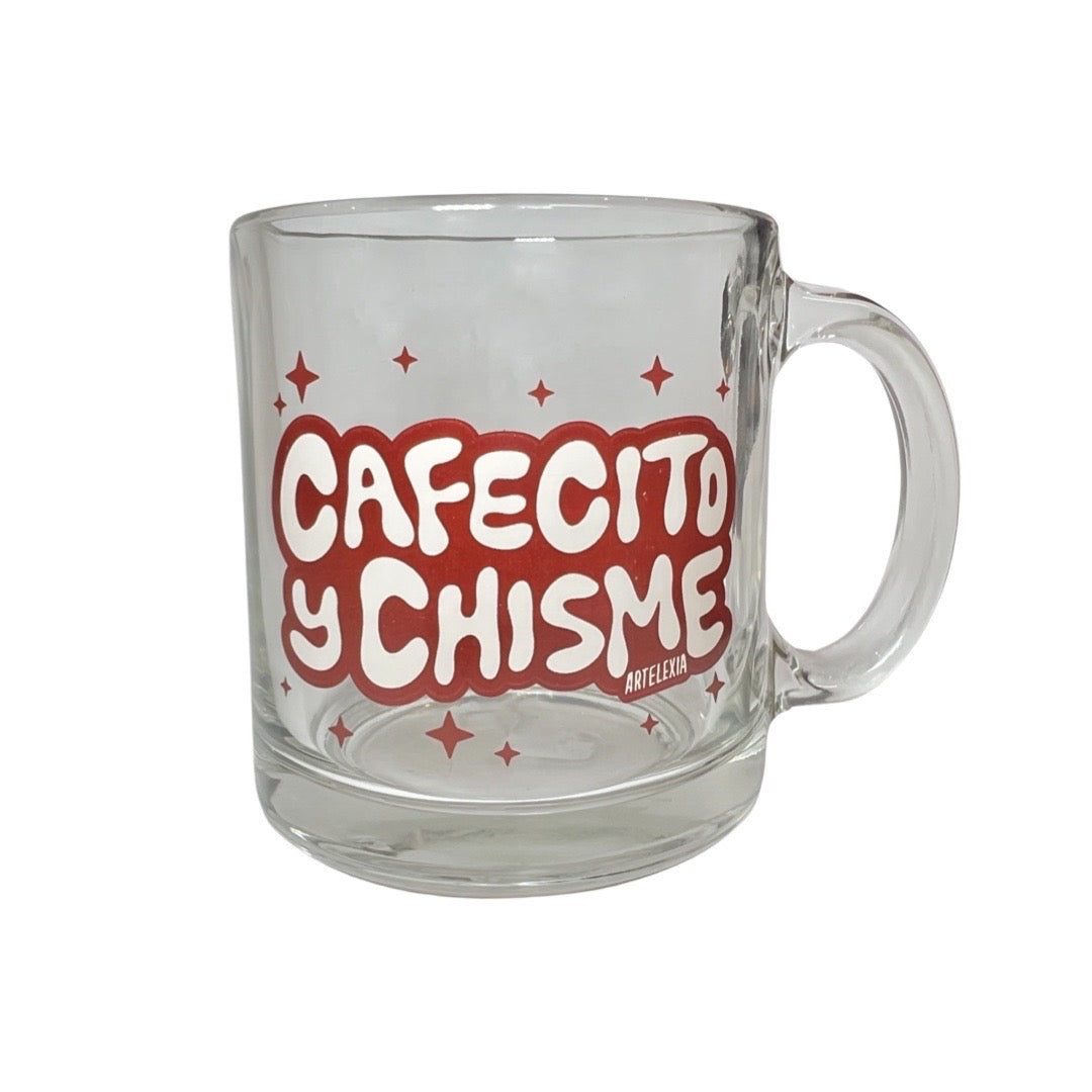 Clear glass coffee mug with the phrase Cafecito y Chisme in brown and beige lettering with brown stars.