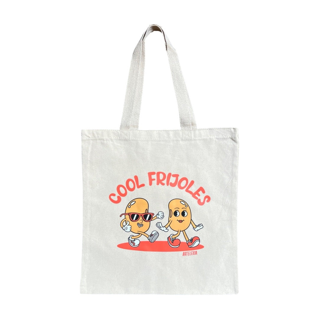 Natural canvas tote bag with an image of two cartoon beans walking and the phrase Cool Frijoles in orange lettering above them.