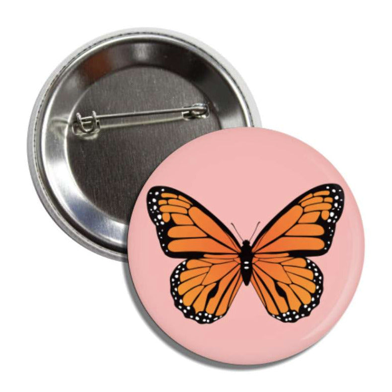 Set of pin-back buttons with one showing the back of it and the other one is blush with an image of a colored monarch