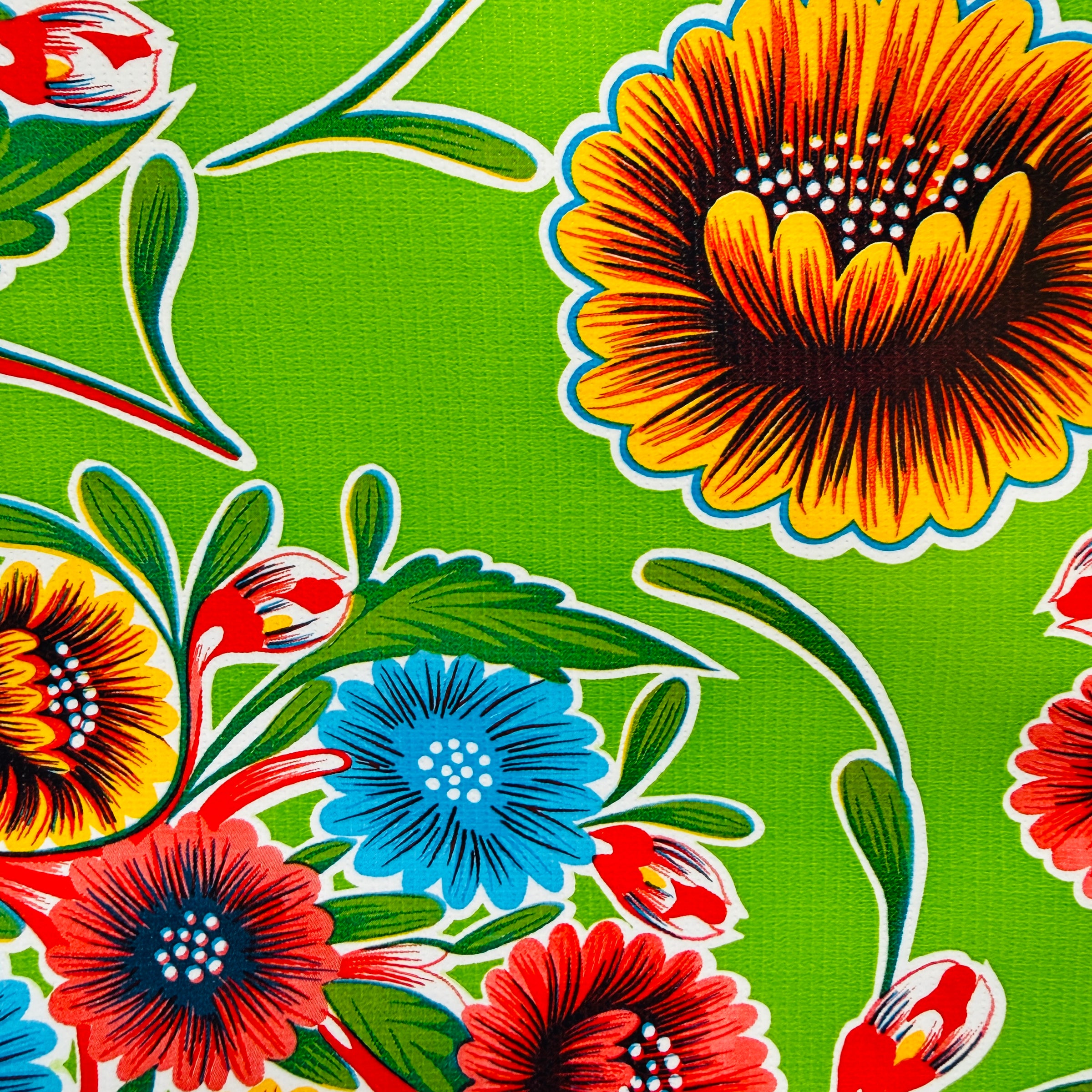 Close up of green bloom oilcloth table cover. Design features colorful floral design.n