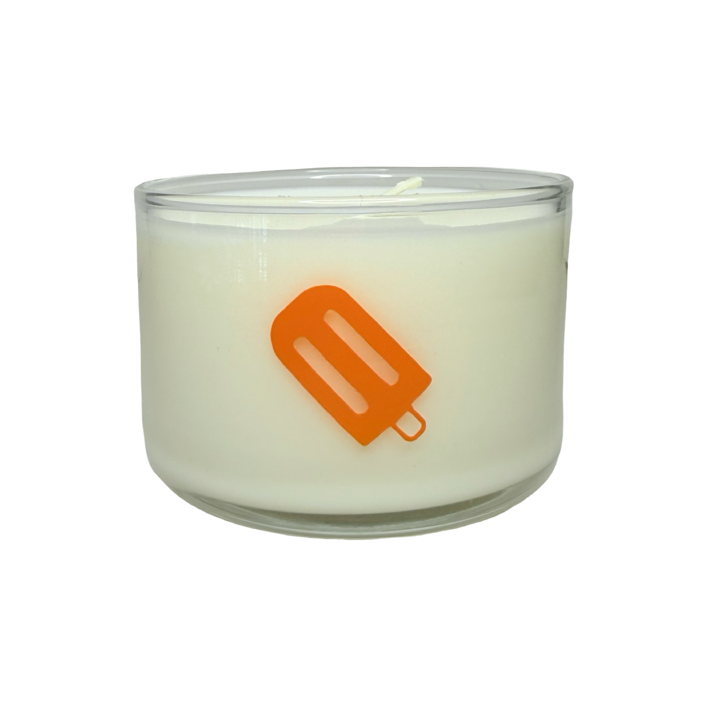 clear jar with a white candle and an orange image of a paleta or popcicle.