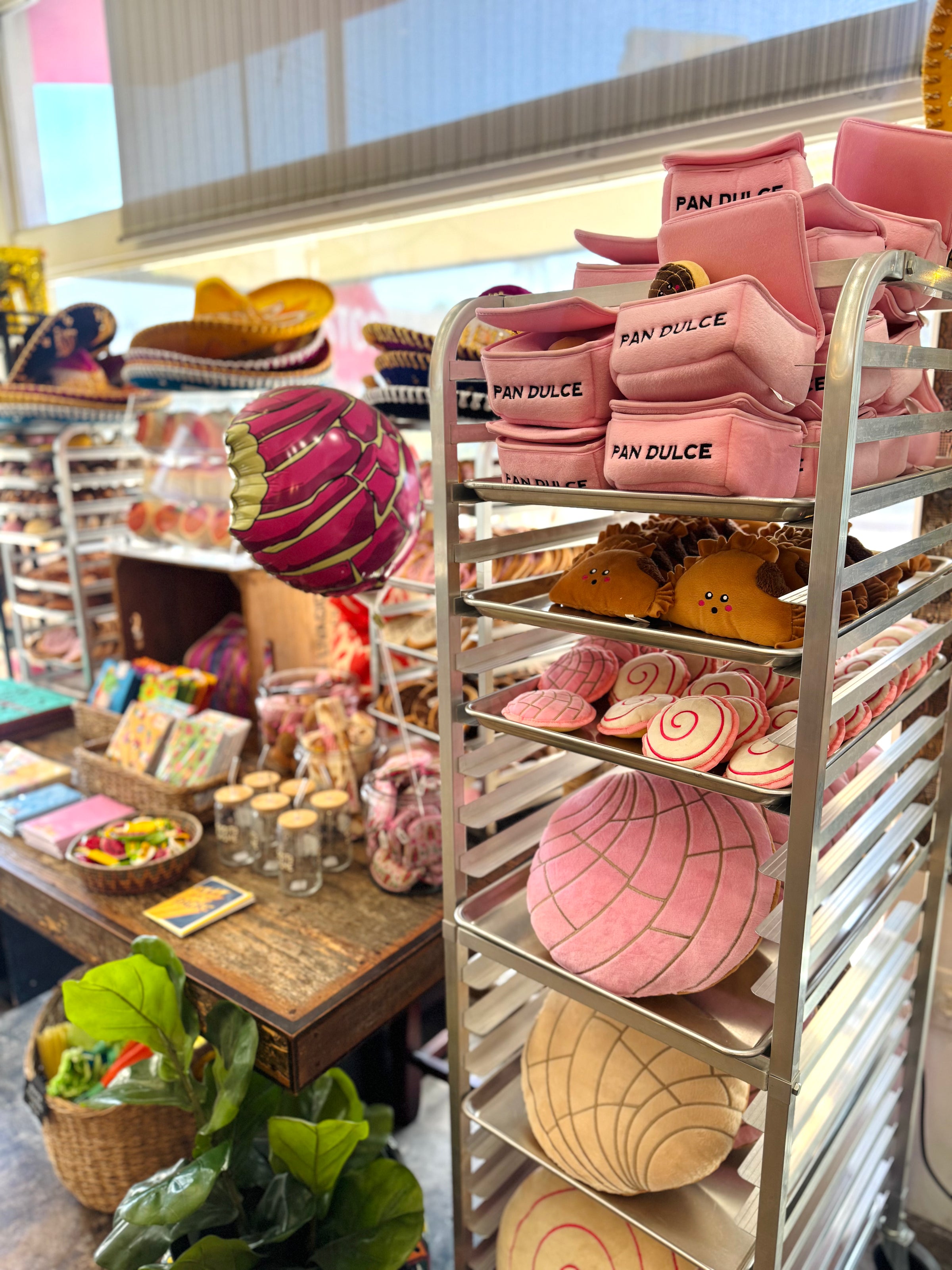 A metal baking rack filled with plush mexican-inspired pan dulce dog toys. 