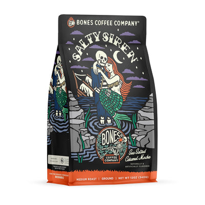 Bones Coffee Company Salty Siren coffee bag, featuring artwork of a skeleton sailor embracing a mermaid by the sea under a crescent moon, labeled “Sea Salted Caramel Mocha Flavored Coffee.”