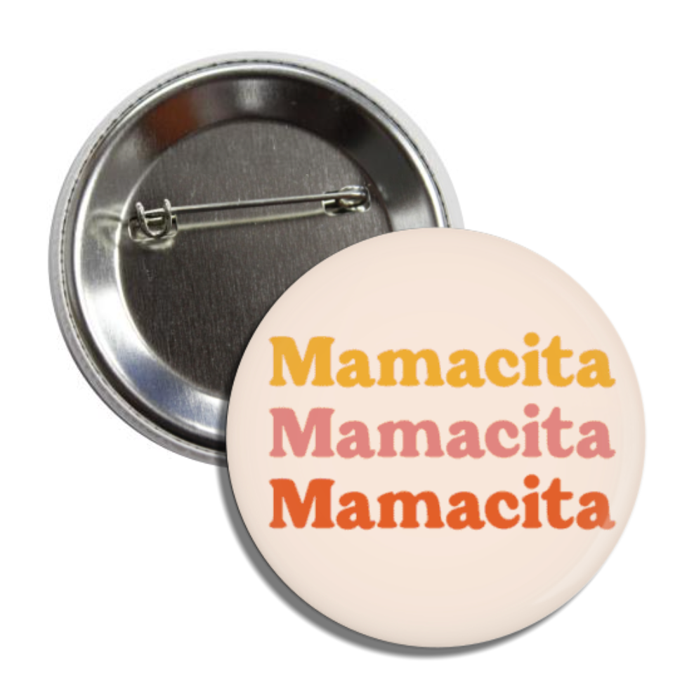 Round pin back button with an ivory background with the phrase Mamacita, 3 times, in yellow, pink and orange lettering.