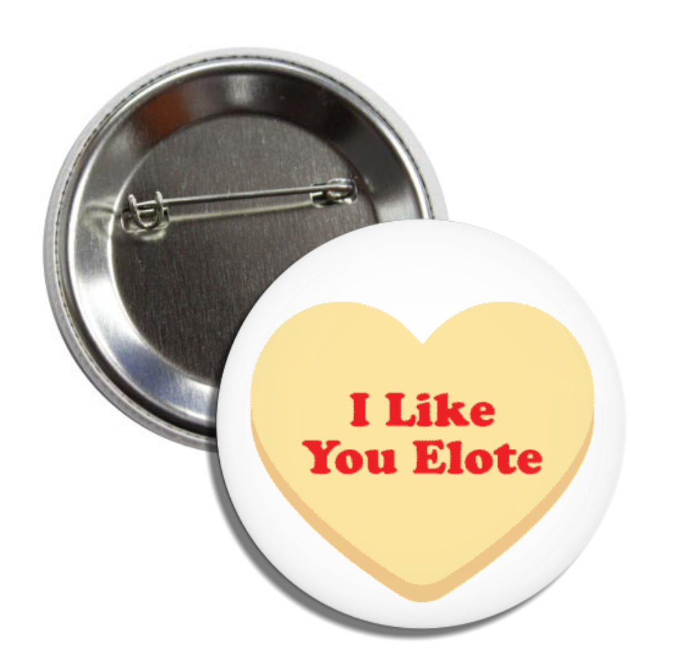 White round pin back pin featuring a yellow heart and the phrase I Like You Elote in red lettering.