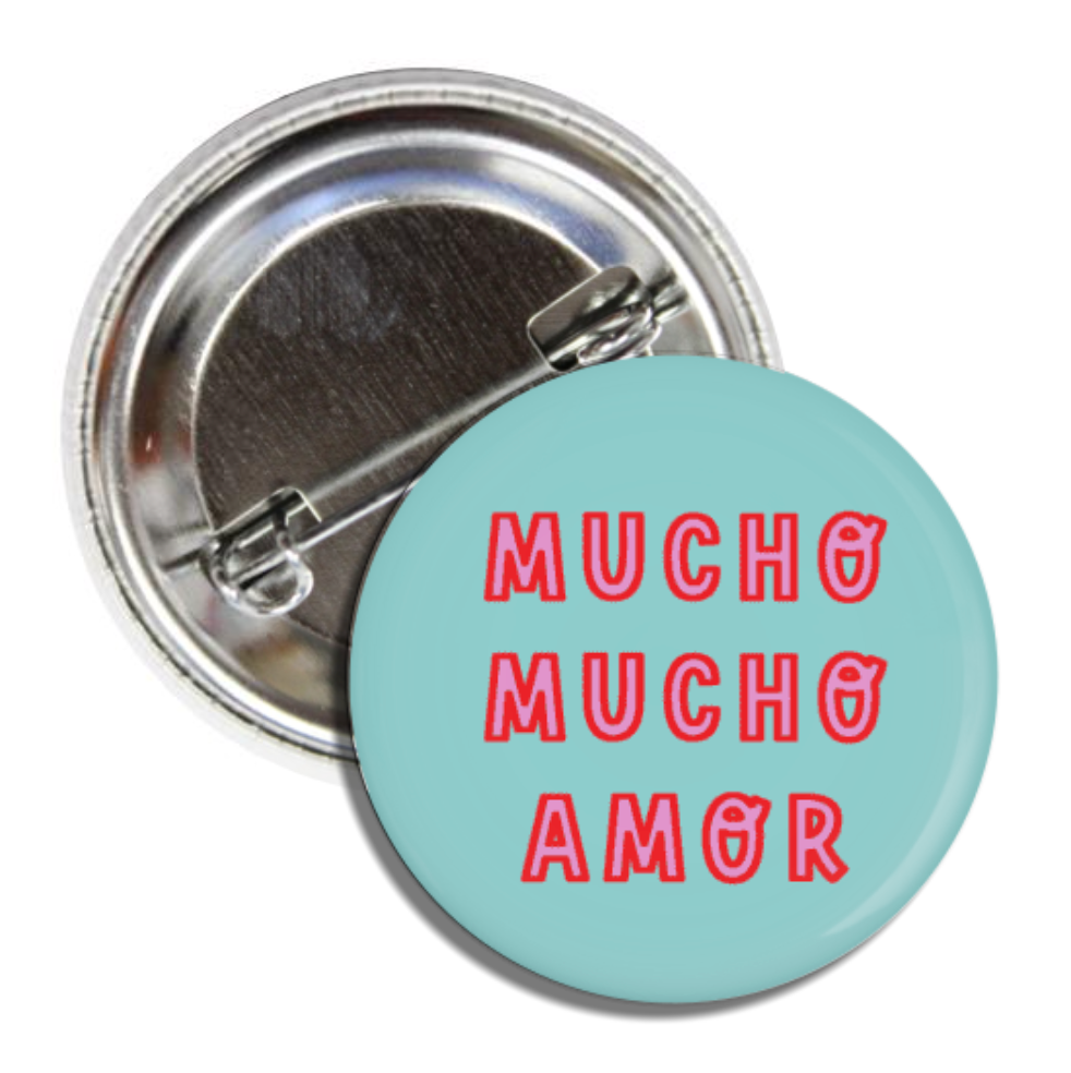 Teal Round pin button with the phrase "Mucho Mucho Amor" in pink and red lettering