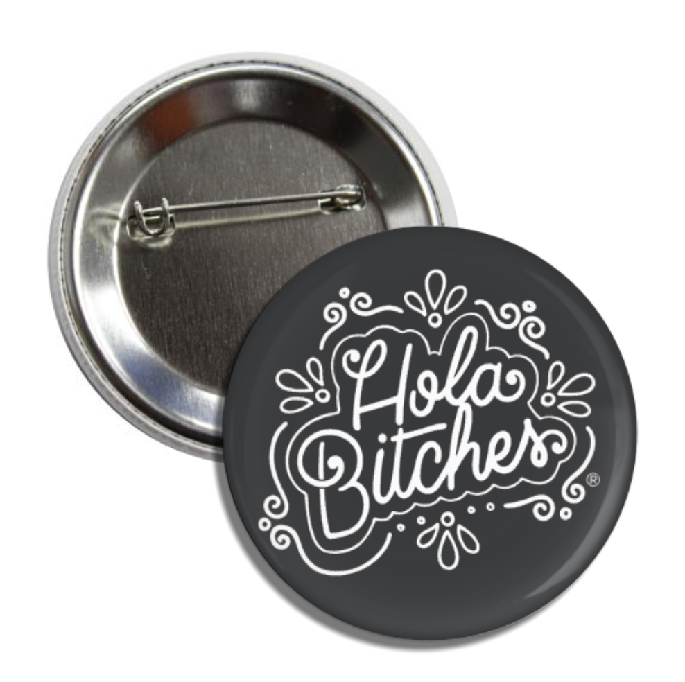 Black round pin button with the phrase Hola Bitches in white lettering