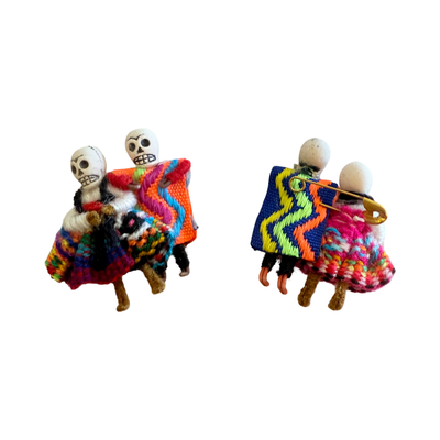 2 sets of miniature handmade pins of dancing skeleton couples—cholitas in colorful ruffled skirts with partners in striped ponchos. one pair is backwards showing the pin.