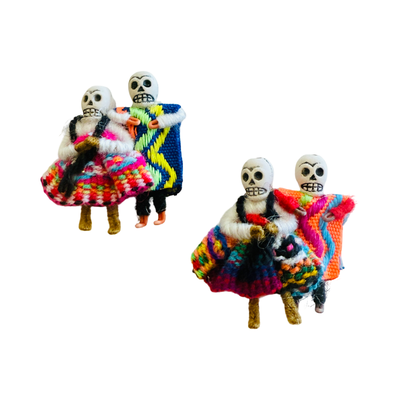 set of miniature handmade pins of dancing skeleton couples—cholitas in colorful ruffled skirts with partners in striped ponchos
