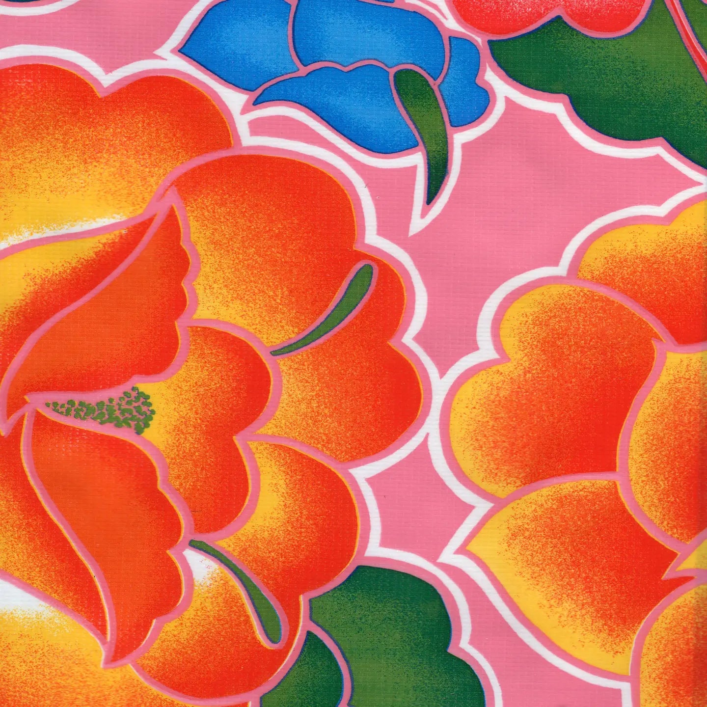 Close-up of a bold floral oilcloth print featuring oversized orange, yellow, blue, and red flowers with green leaves on a pink background.