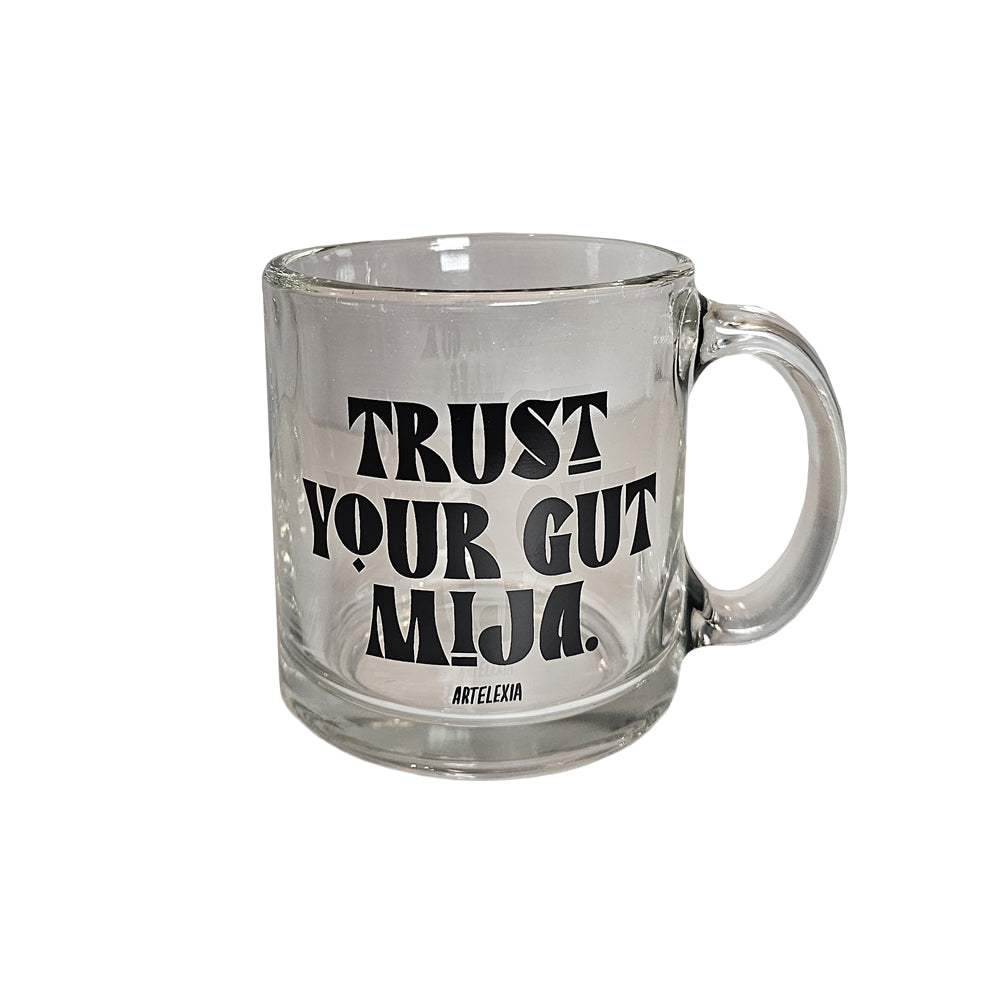 Clear Glass mug with the phrase "Trust Your Gut Mija" in black lettering with the Artelexia logo underneath