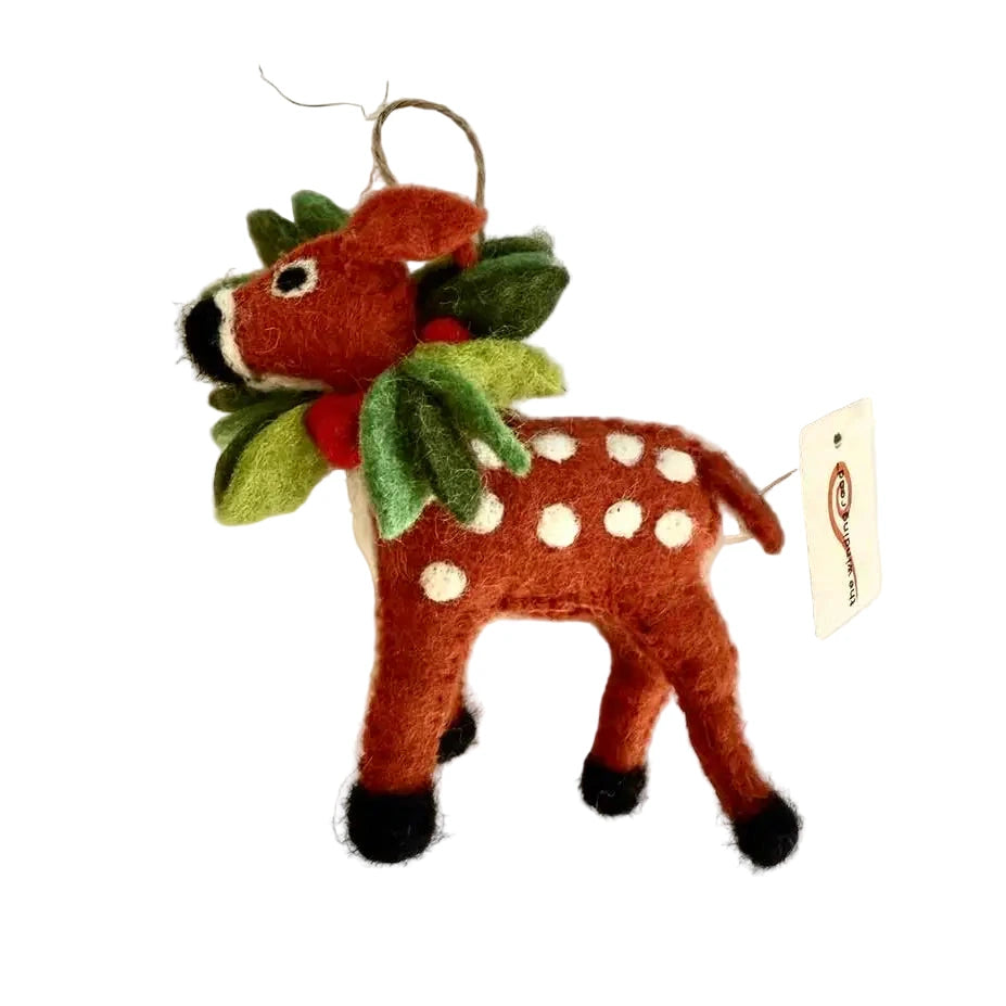 Felt deer ornament with white spots, black hooves, and a green holly wreath with red berries, hanging by a twine loop.