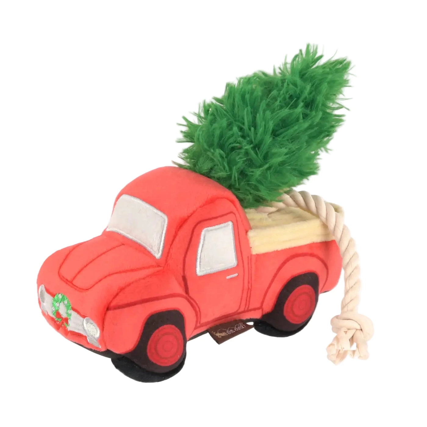 Plush red truck dog toy with a green Christmas tree in the back and a knotted rope attached to the rear for tugging.