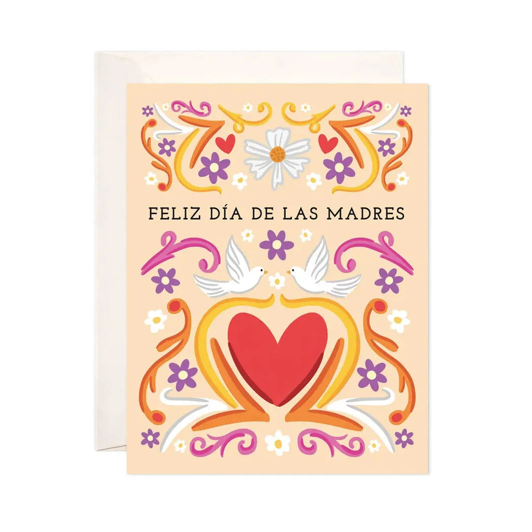 peach card with a red heart, two white doves, various flowers and designs featuring the phrase Feliz Dia De Las Madres