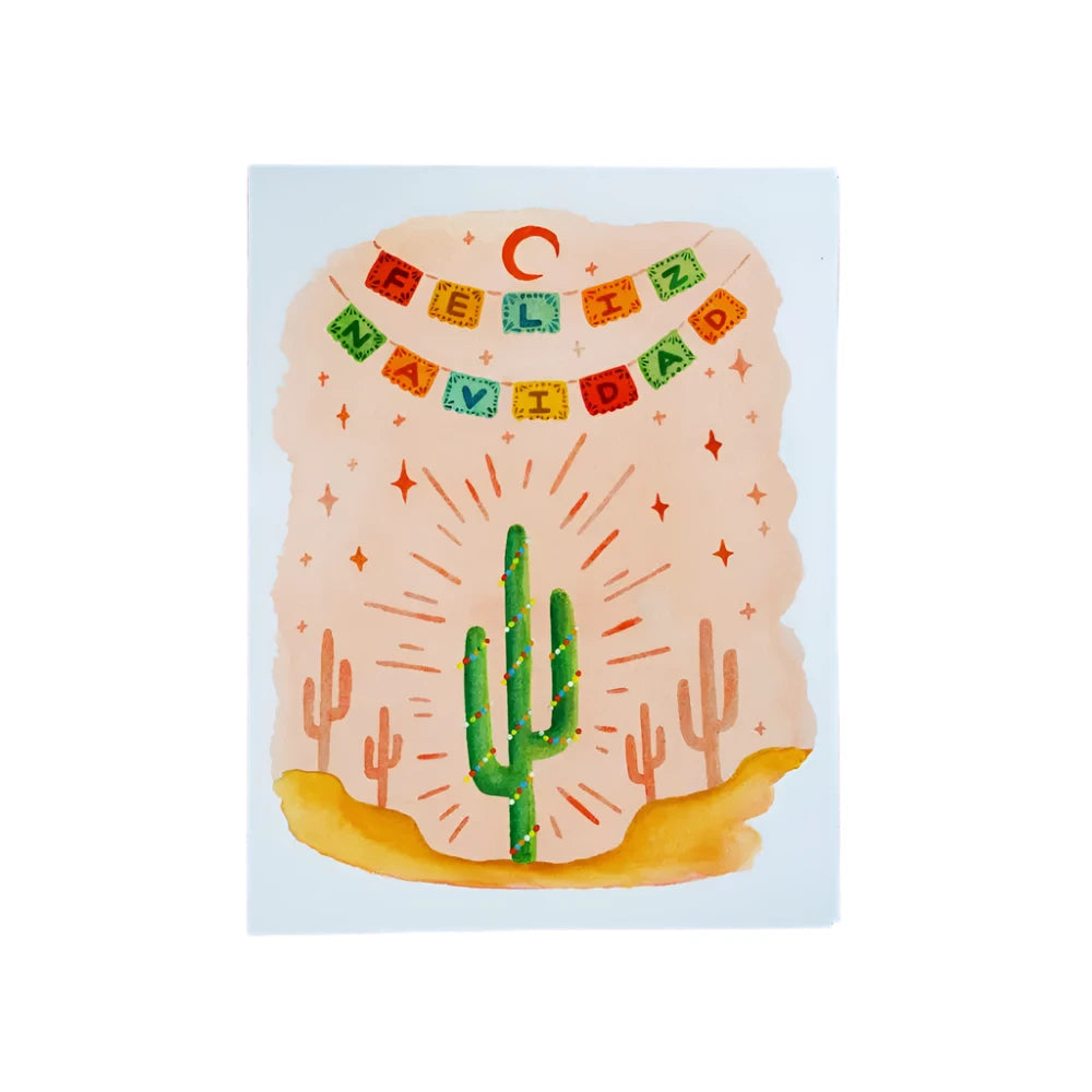 Greeting card with "Feliz Navidad" written on a colorful papel picado-style banner, featuring a cactus wrapped in string lights and surrounded by a desert landscape with bright star accents