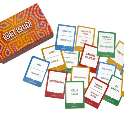 ¡Get Loud! game box and a spread of colorful bilingual word cards featuring terms like "Navidad/Christmas," "Celia Cruz," and "Biblioteca/Library," arranged on a white surface, showcasing the vibrant and engaging gameplay.