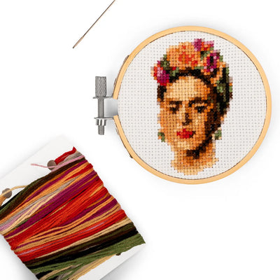 round embroidery kit with an image of Frida Kahlo, colorful yarn and a needle.