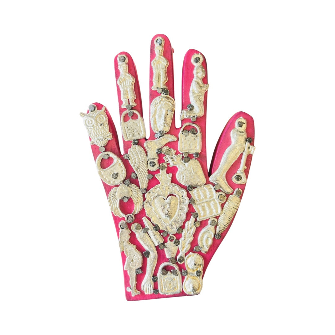 Handmade wooden milagro hand in pink. Design features a variety of mini milagro charms.