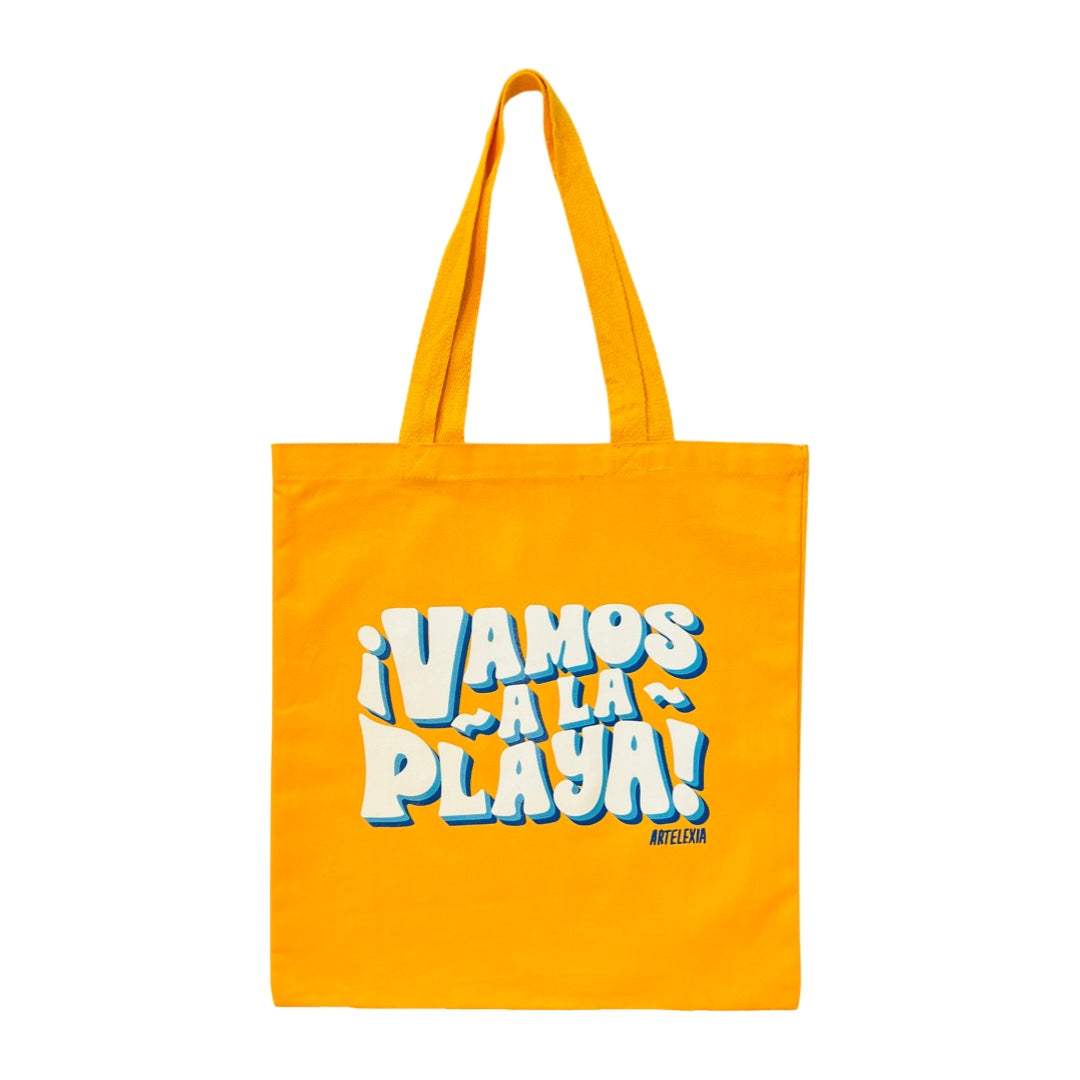 Yellow tote bag with the phrase Vamos A La Playa in white and light blue lettering.