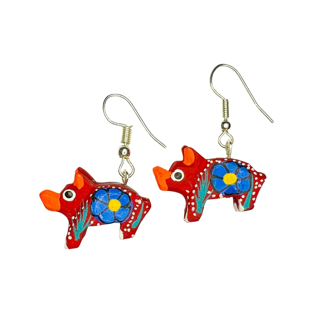 A set of alebrije pig earrings of various colors and design