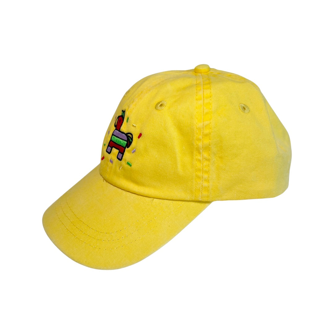 side view of a yellow kid's hat with an image of a colorful pinata