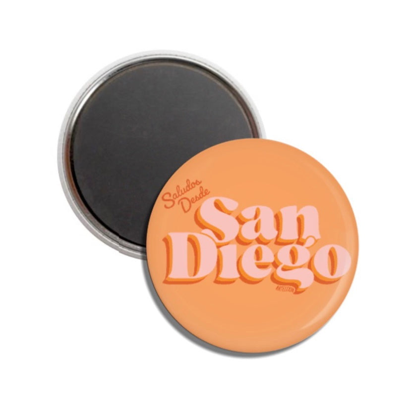 Set of round orange magents with the phrase Saludos Desde San Diego in light pink and orange lettering.