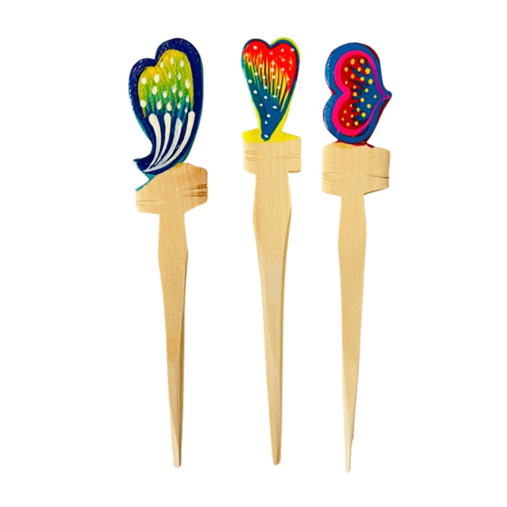 a trio of wooden toothpicks with a heart design painted on the top