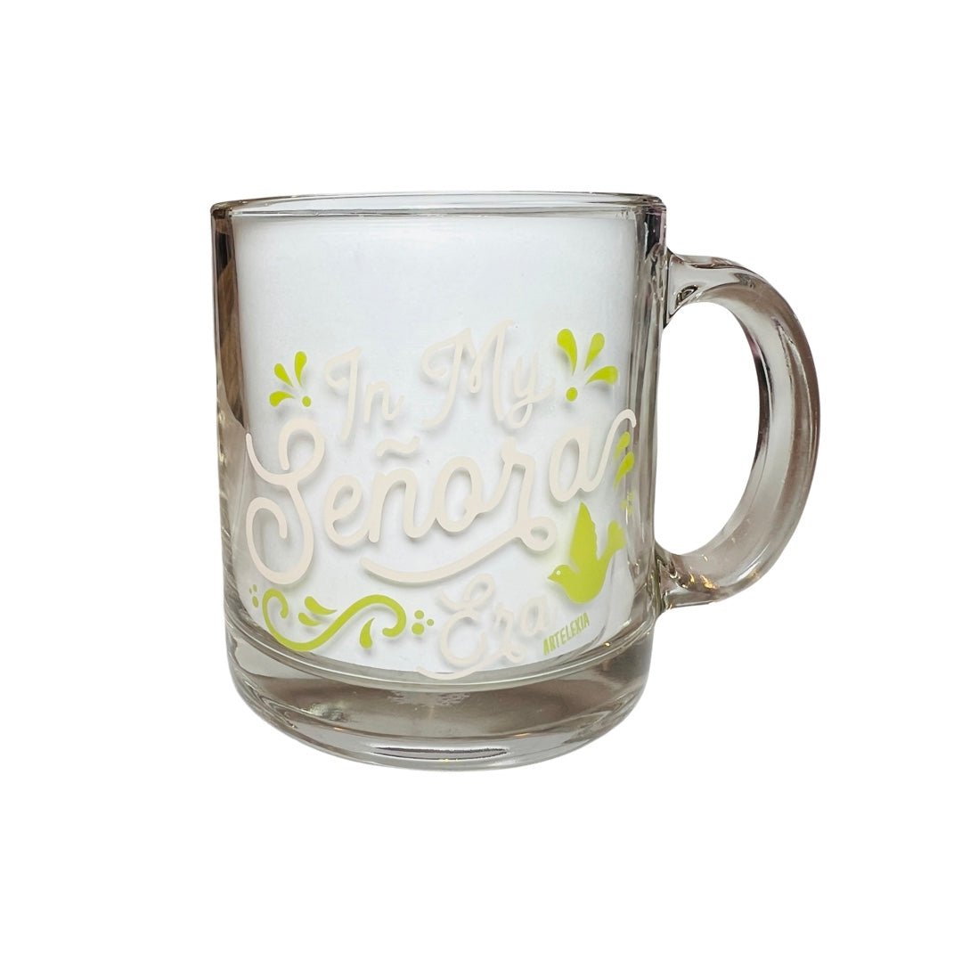 Clear glass mug with the phrase In My Senora Era in cream lettering and light green filagree