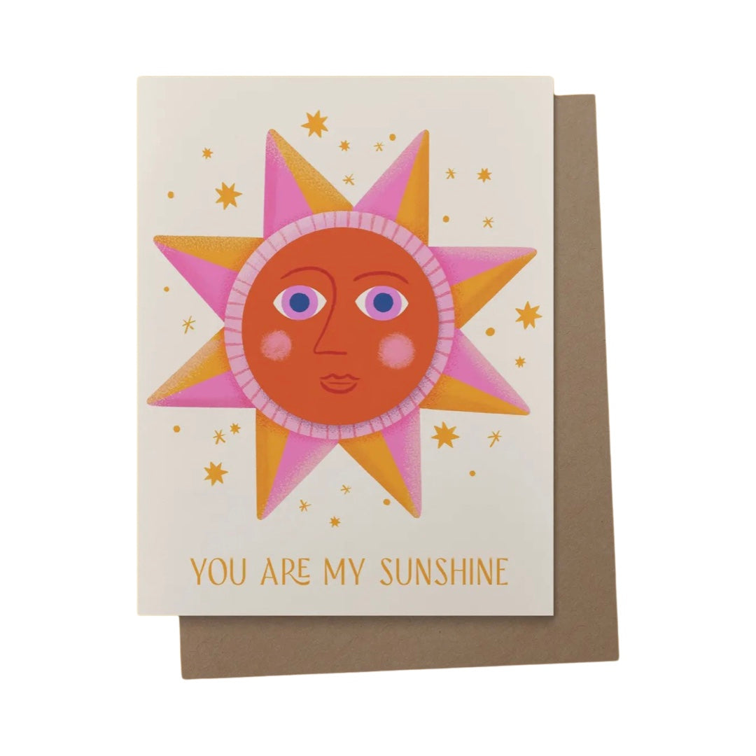 beige card with an abstract image of a pink and orange sun with the phrase You Are My Sunshine.
