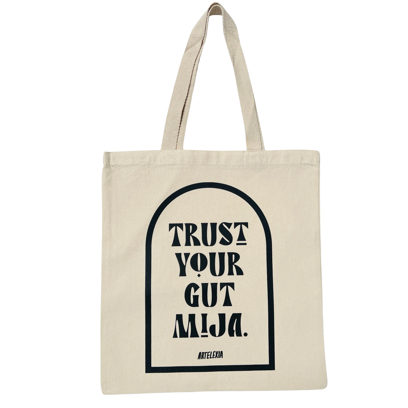 Natural canvas tote bag with the phrase Trust Your Gut Mija in black lettering with a black outline of an arch surrounding it.