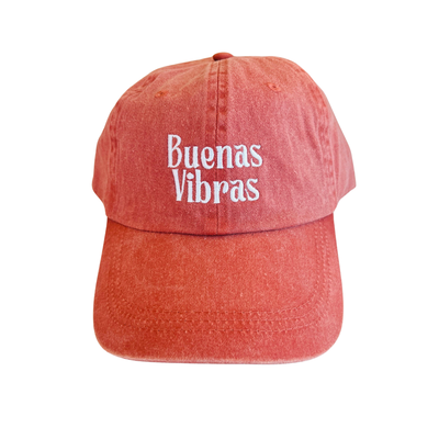 coral hat with the phrase Buenas Vibras in white lettering