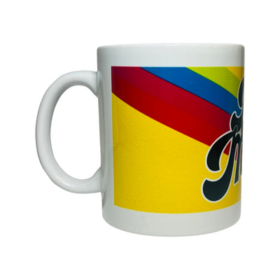 Side view of a White Ceramic mug with the phrase Dog Mama in black lettering over a yellow, red, blue and green back ground.